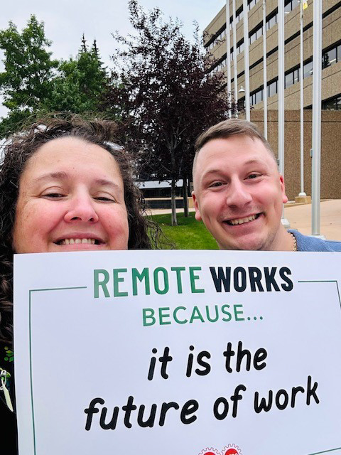 des participants tenant une pancarte « remote works » parce que c'est l'avenir du travail
