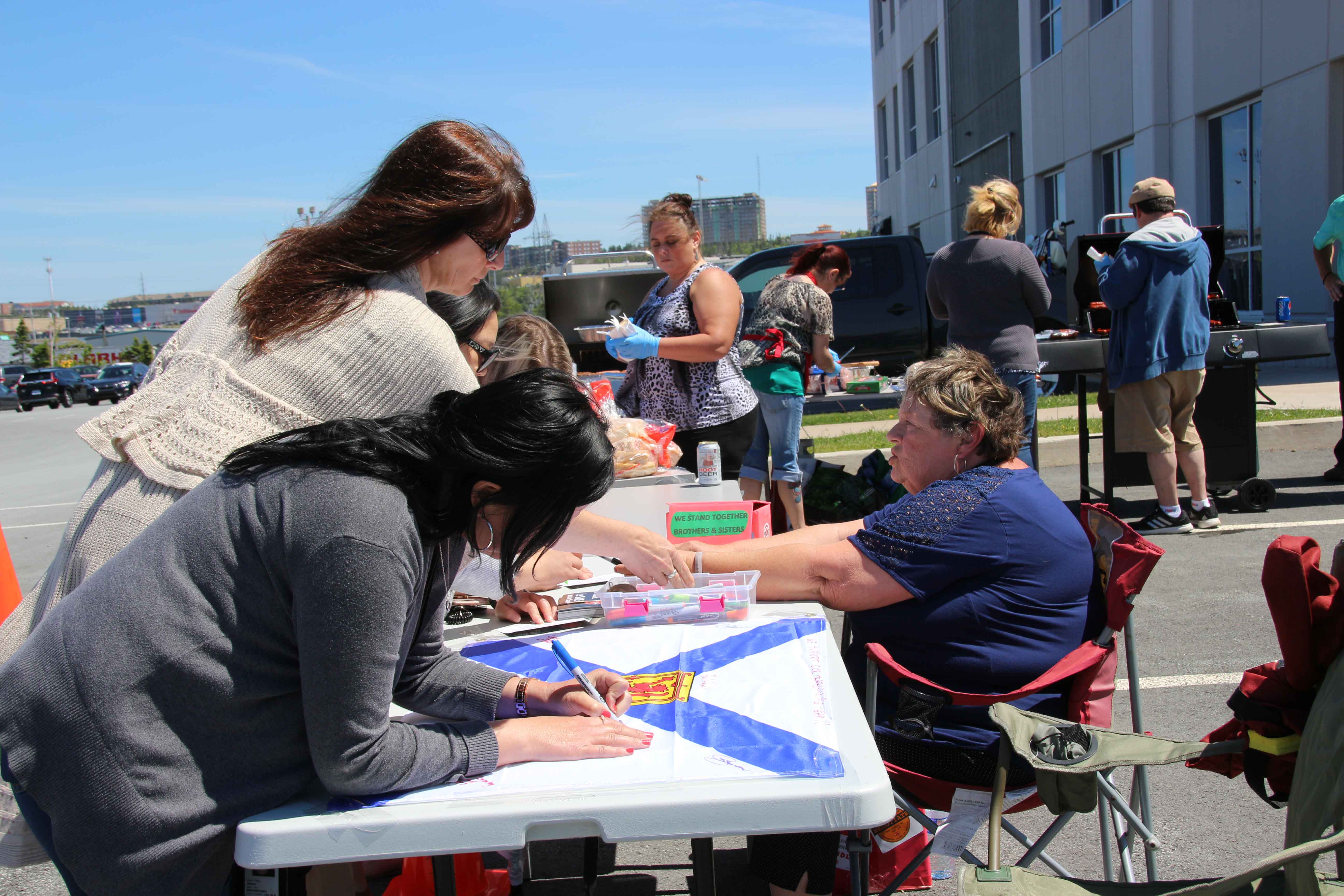 Karen Henderson having members sign flag and explaining the CAS campaign